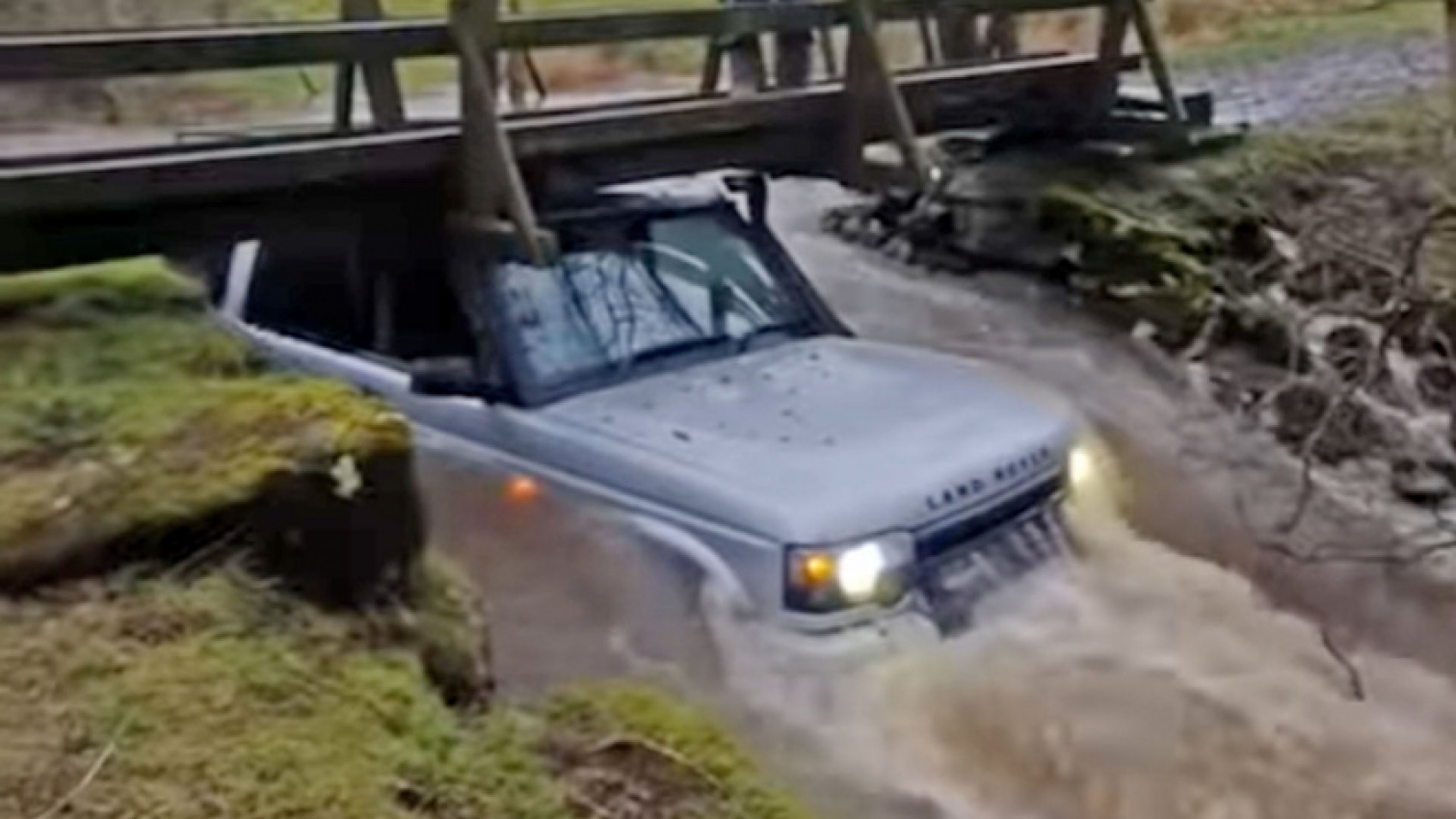 autos, cars, land rover, man’s land rover adventure ends stuck under a footbridge in floodwaters