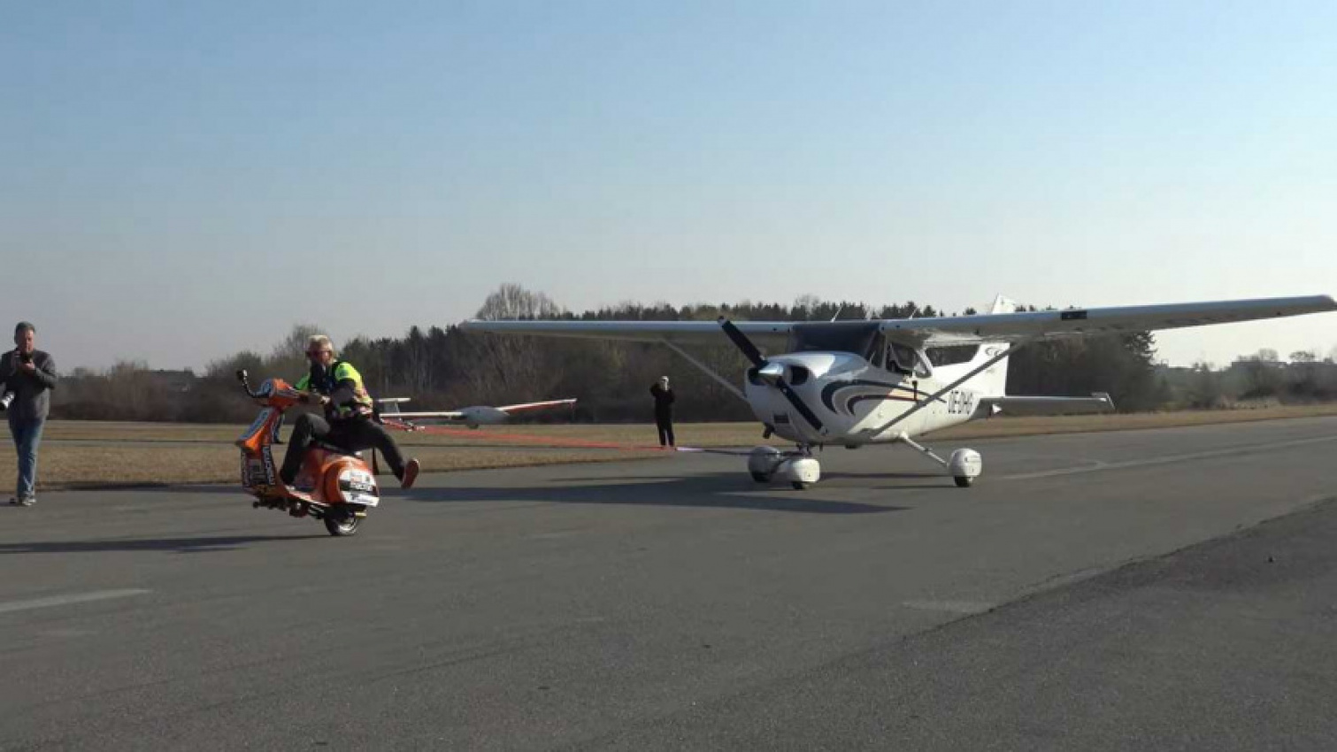autos, cars, piaggio, vespa, watch this vespa stuntman pull a plane down a runway with his scooter