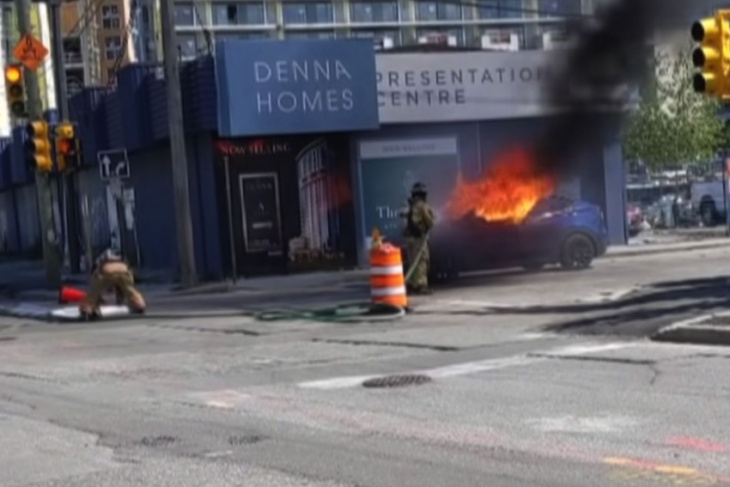 watch: tesla driver kicks out window after car locks doors, catches fire 