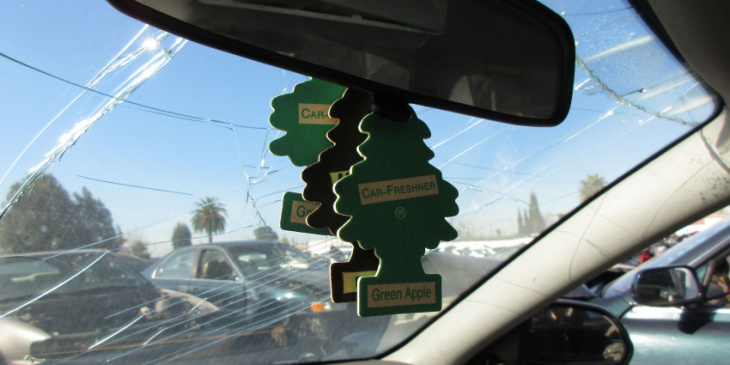 green apple car-freshner little trees in junkyard cars