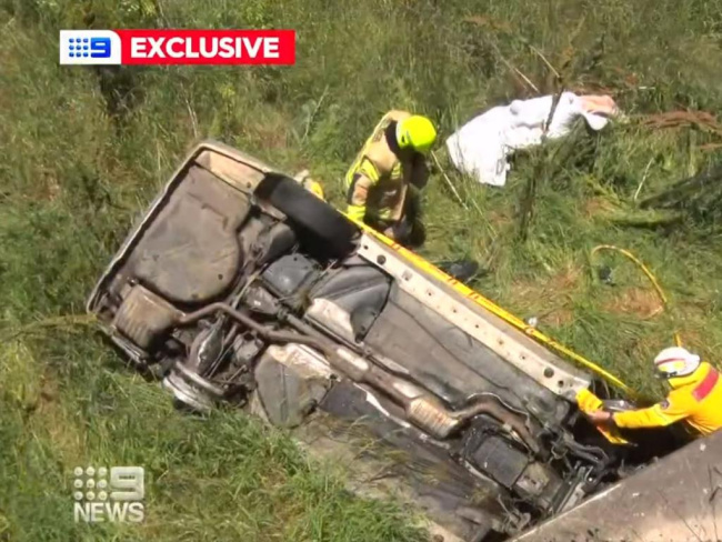 Emergency service workers examine the Mercedes after its driver plummeted eight metres off the Great Western Highway on Thursday afternoon. Picture: 9News, Police officers chased alongside the car before the 33-year-old male drove into a creek in a wild attempt to evade capture. Picture: 9News, National, NSW & ACT, Man drives Mercedes into creek in desperate attempt to evade police