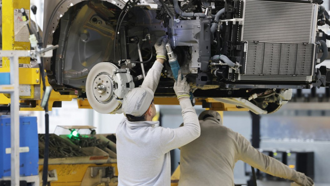 Renault factory: worker installing front suspension components