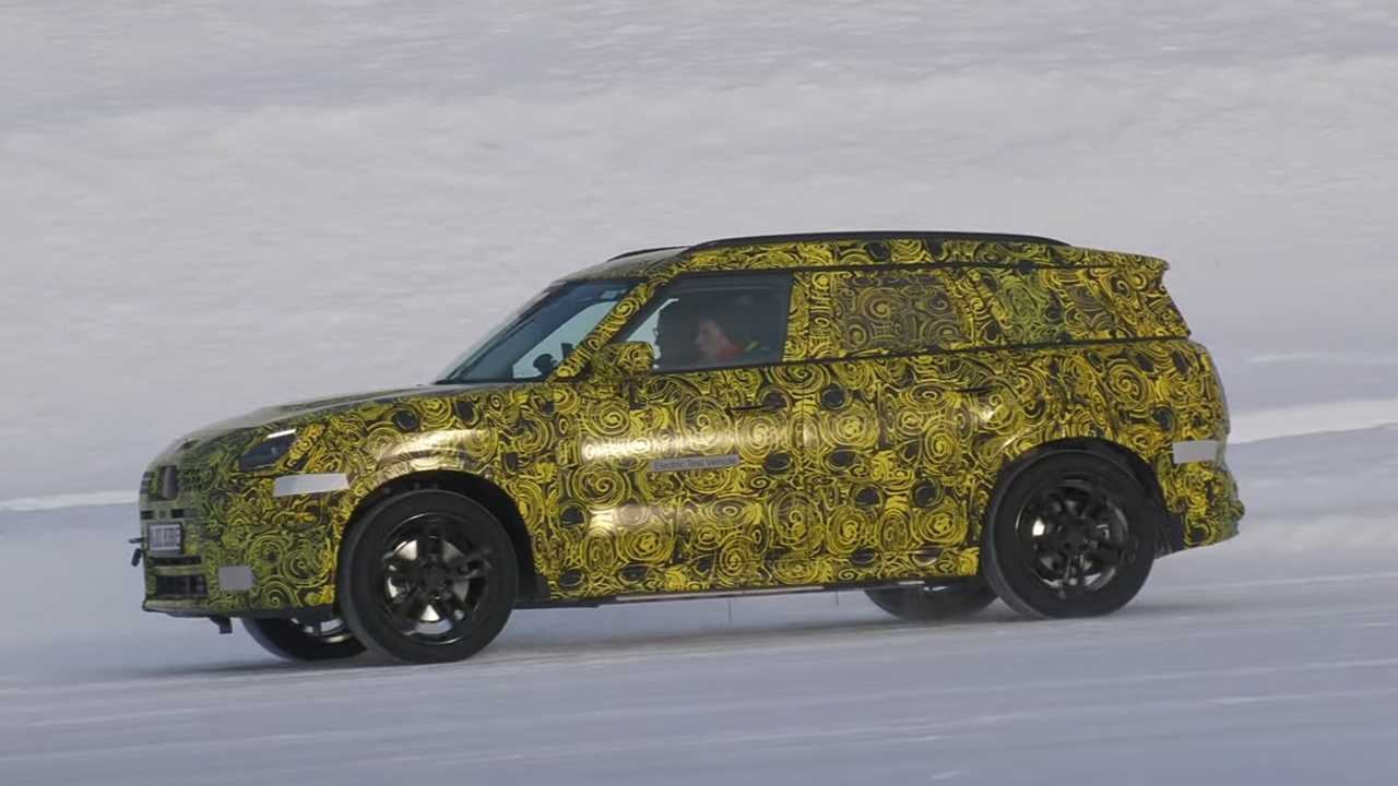 The side view of a Mini Countryman EV prototype vehicle, driving in snow.