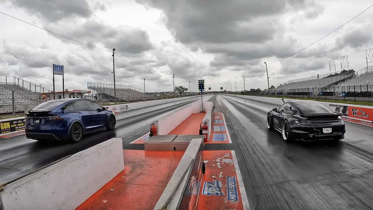 A Tesla Model X and a Porsche 911 Turbo S sit at the starting line on a drag strip.