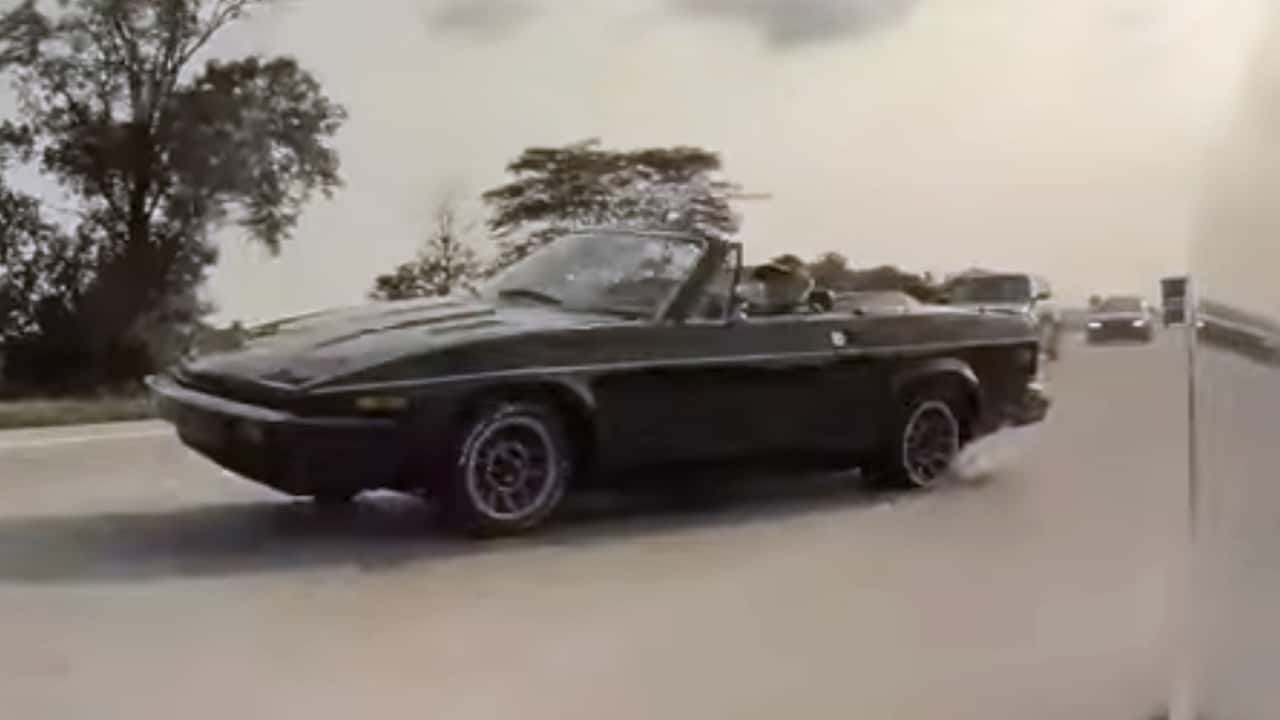 A Triumph TR7 spinning out on a highway.