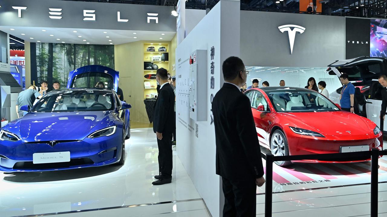 Tesla unveiled the new Model 3 in China, where it is built. Photo: Wang Zhao/ AFP, The Model 3 drives the rear wheels in standard form., White seats are optional, but a glass roof is standard., Back seat passengers get their own touchscreen., Tesla’s popular ‘dog mode’ feature remains standard., New lights and wheels are part of the deal., Tesla has upgraded the Model 3 for 2024., Technology, Motoring, Motoring News, How Tesla is fighting back with the new Model 3
