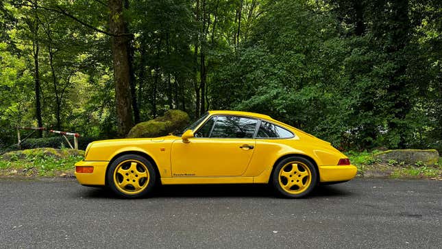 A yellow 1992 Porsche 964 Carrera 2 Coupe Clubsport prototype is parked in the Black Forest