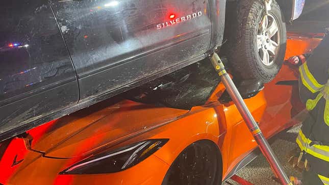 A black Chevy Silverado stuck atop an orange Corvette