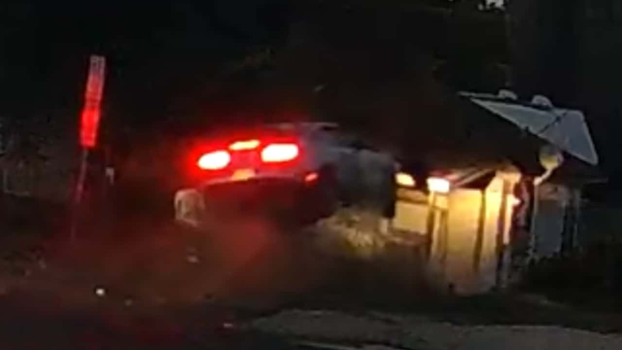 Ford Mustang goes airborne and crashes into home. 