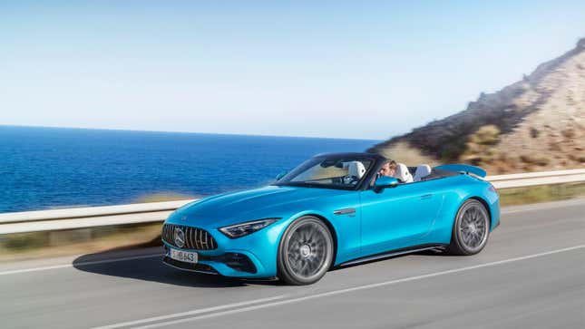 A blue 2023 Mercedes-AMG SL43 convertible is driving along the coast with its top down