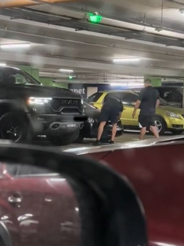 Two men could be seen attempting to reattach the front bumper bar. Picture: TikTok, The large pickup truck allegedly ‘sideswiped’ a sedan while parking. Picture: TikTok, Technology, Motoring, Motoring News, Pickup ‘monster truck’ carpark sideswipe crash sparks outrage
