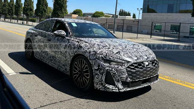 Front 3/4 view of a camouflaged next-gen Audi S5 Sportback in traffic